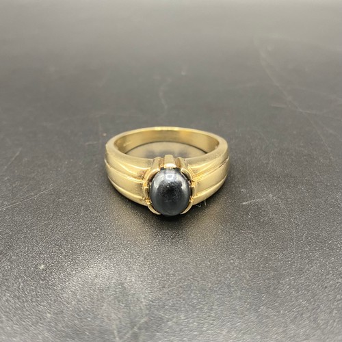 956 - 9ct gold ring with a hemetitle/cats eye stone. 6.5g Size U.
