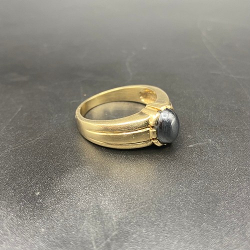 956 - 9ct gold ring with a hemetitle/cats eye stone. 6.5g Size U.