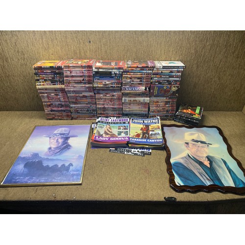 87 - Large collection of John Wayne and Clint Eastwood DVDs and two pictures. (two boxes).