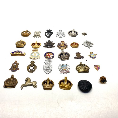 779 - Aprox 29 military badges and collectibles.