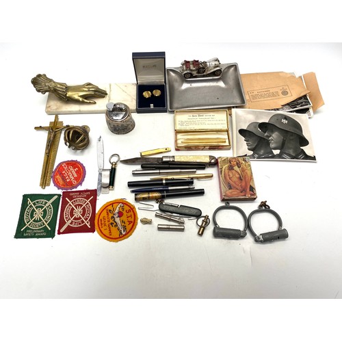 593 - collection of curiosities including brass crucifix, adult playing cards, and a table lighters.