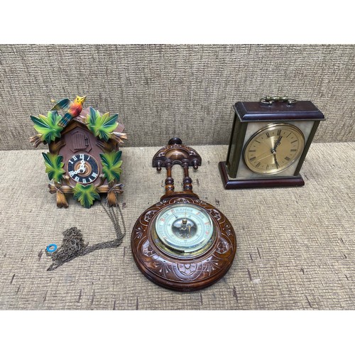 426 - wooden Barometer, metallic mantle clock and a cuckoo clock.