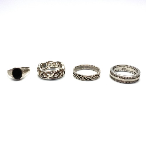 783 - Four silver rings. One circular with CZ stones size Q, Large celtic band size M, Onyx stone size M a... 