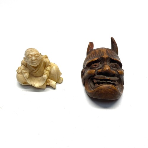 929 - Two netsukes a rare wooden devil shield and a buddha.