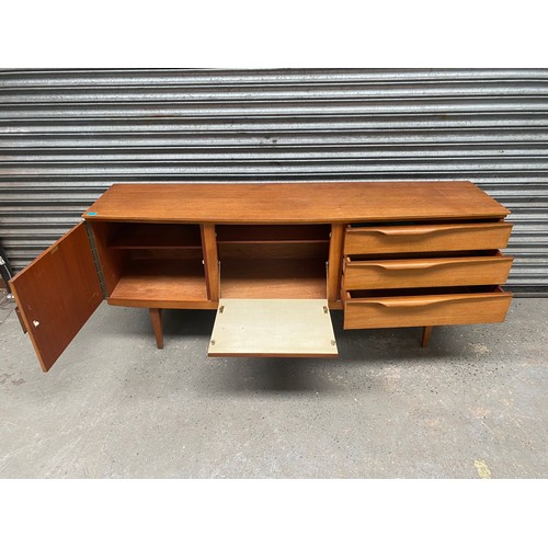 1001 - Mid-century beautility teak sideboard with carved handles c.1960, H: 78cm W: 184cm D: 48cm.