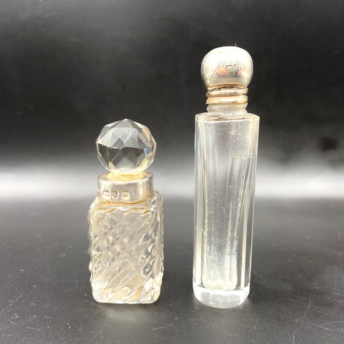 703 - Two cut crystal power/perfume bottles with silver lids, one with hallmarks for Chester 1912 and Birm... 