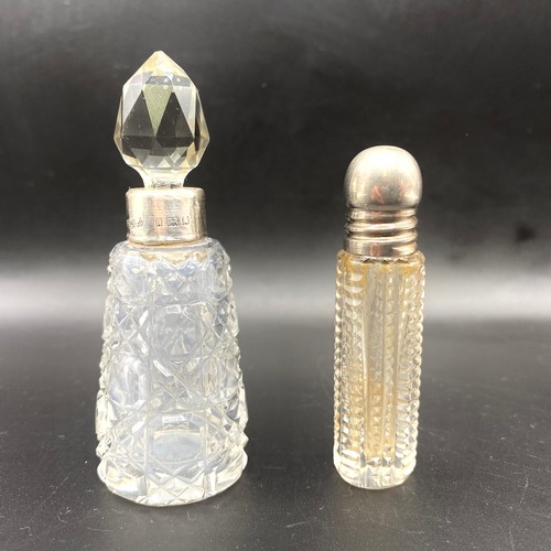 704 - Two cut crystal powder/perfume bottles with a silver lid and rim, one with London marks for 1925 by ... 