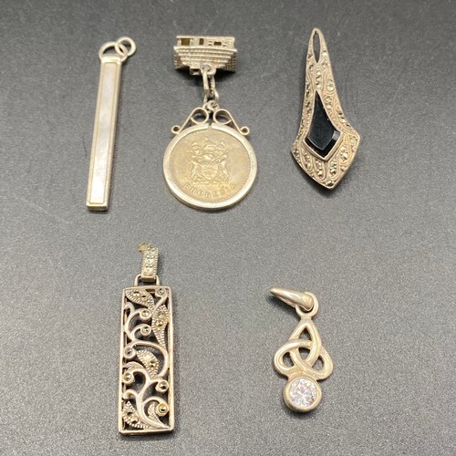 824 - Five silver brooches and pendants.