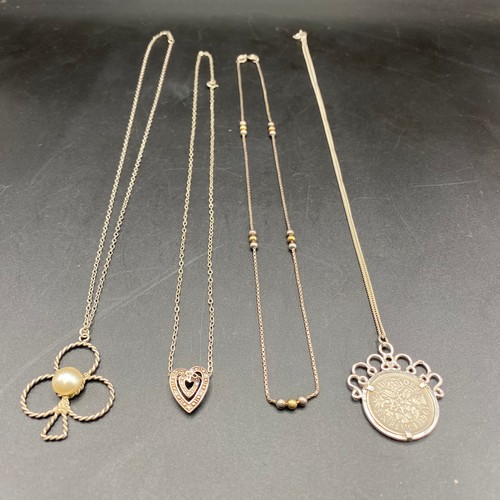 695 - Four silver chains and pendant including a 1961 mounted six pence.