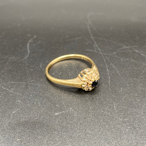 873 - 9ct gold and diamond cluster ring with a black sapphire. Size O and 2g.