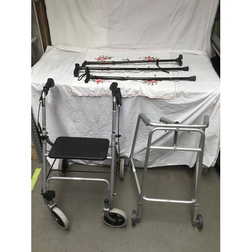 279 - Two mobility walkers one with a seat and three walking sticks