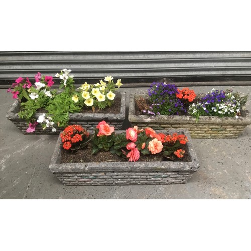 73 - Three reconstituted stone planters with flowers