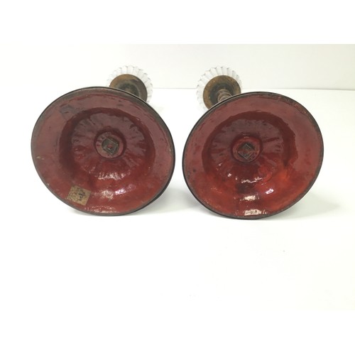 722 - A pair of continental brass candlesticks with barley twist design and a red enamelled underside