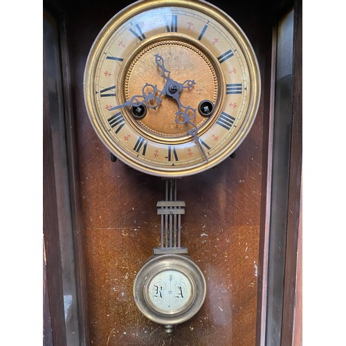 1115 - Stunning antique mahogany wall hanging clock enamel face and brass cogs with key.