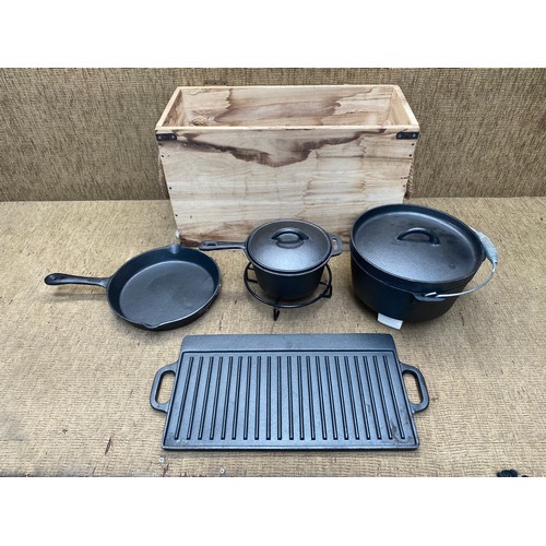 1121 - storage box with heavy cast iron camping cookware including: Boiling pot, Saucepan and frying pan.