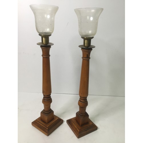 475 - A pair of wooden candlesticks with glass shades