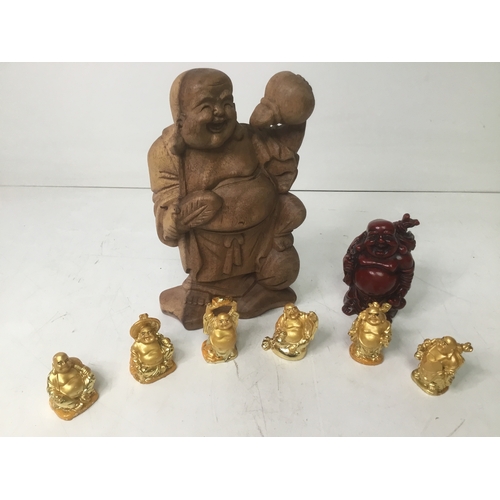 434 - A collection of Buddhas including six gold laughing, red resin and a wooden carved Buddha