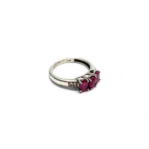 940 - Silver ring with Rubies and diamond shoulder stones, size O.