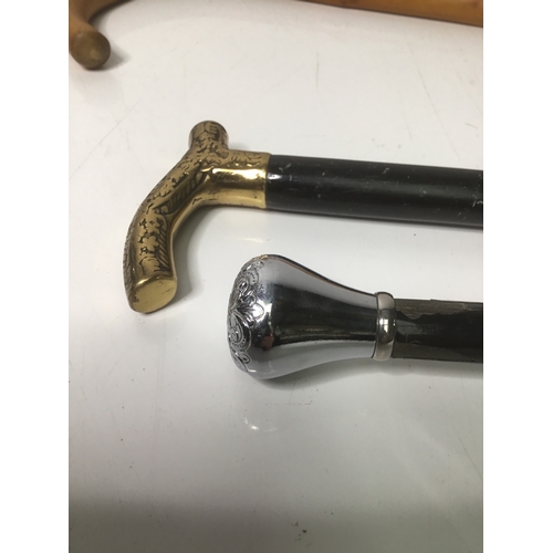 676 - Two walking sticks and two walking canes one with a brass handle