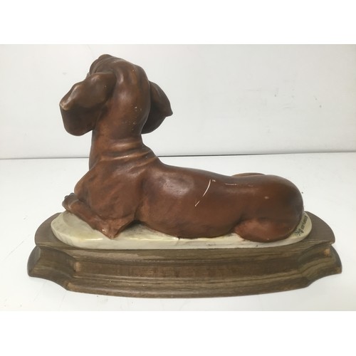 709 - Guissepe Armani dog sculpture on a wooden plinth 25cm x 18cm