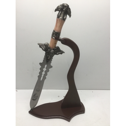 665 - Decorative hunting knife on a display stand. Over 18 items, please note these items will not be post... 