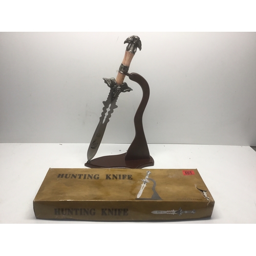 665 - Decorative hunting knife on a display stand. Over 18 items, please note these items will not be post... 