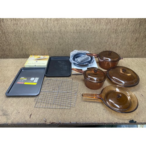 229 - mitchen items including cheese board with cutter, sauce pans and oven trays.