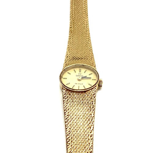 873 - 9ct gold ladies Omega Deville oval  face watch and strap. Running when booked in. Total weight with ... 