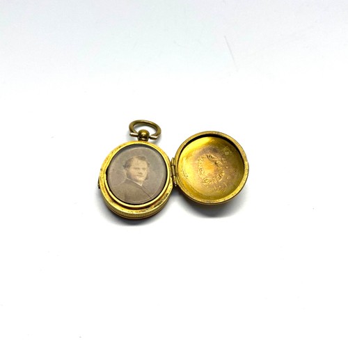 803 - Early brass double locket with original water coloured from black and white pictures. Presumed Circa... 