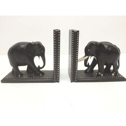 895 - A pair of black ebonised elephant bookends with faux ivory inserts (slight damage)