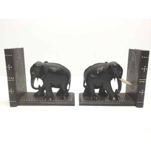 895 - A pair of black ebonised elephant bookends with faux ivory inserts (slight damage)