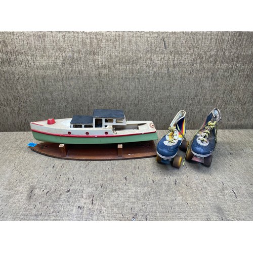 1349 - Tri-ang hand crafted wooden boat and a pair of 80s roller skates.