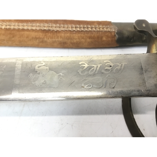 831 - Indian sabre with a brass tiger head handle in a decorative sheath