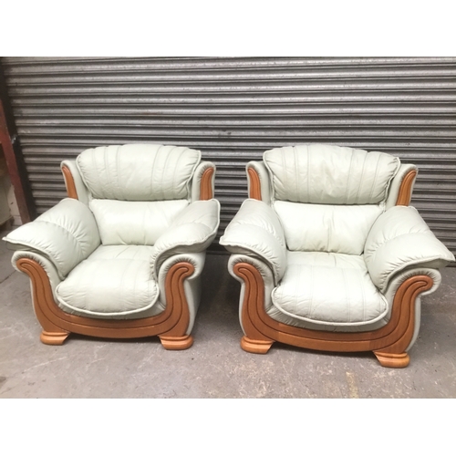 62 - A pair of light green leather armchairs made in USA