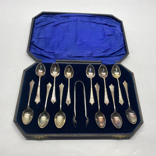 1008 - Boxed set of silver plated Art Deco 12 spoons and tongs in a blue velvet-lined case. Likely to be Th... 