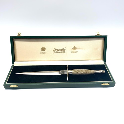 1220 - Wilkinson Sword Commando dagger in a green leather box and black velvet lining. Engraved to the rear...