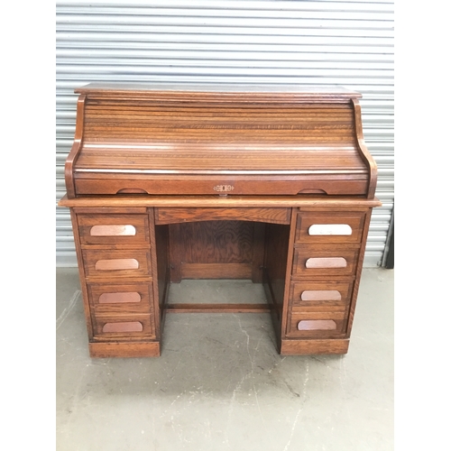 6 - Antique Oak Roll-Top Desk, circa 1910. Features a slatted tambour front with a carved crescent finge...