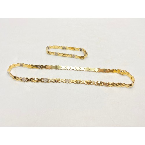 1266 - A refined 14ct gold necklace and bracelet set, distinguished by its sculptural sequence of interlock...