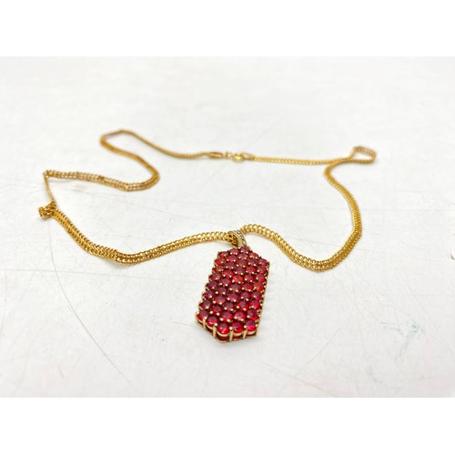 1287 - 9ct gold necklace with a rounded‑rectangular cluster pendant set with uniform red stones in fine pro...