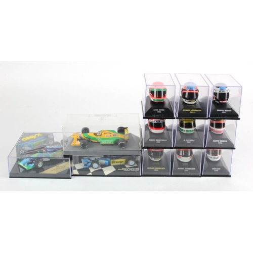 83 - Minichamps. A collection of nine cased Minichamps helmets, together with three cased F1 racing car m... 