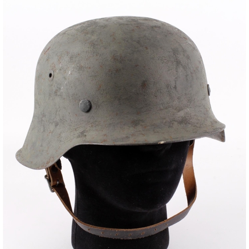 1207 - German Combat helmet, a raw edge example, complete with liner & chinstrap, green sand painted