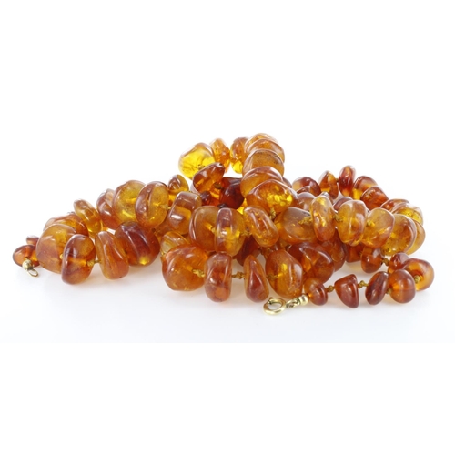 76 - Interesting long row of natural shaped graduated cognac amber beads with 9ct bolt ring clasp, length... 