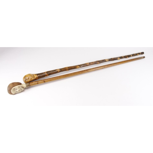 1053 - Two walking sticks each with carved head knop, circa late 19th to early 20th Century, length 85cm & ... 