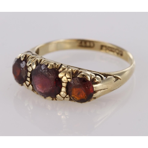 72 - 9ct yellow gold graduated three stone garnet ring, finger size L, weight 2.1g