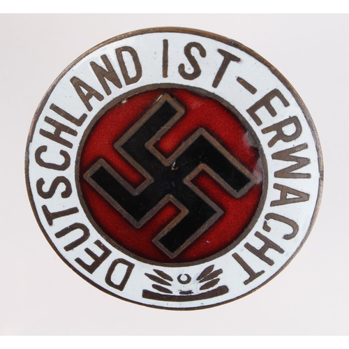 1490 - German Nazi enamelled badge 'Deutschland 1st - Erwacht'. Marked 'Ges Gesch' on the reverse. (5cm)