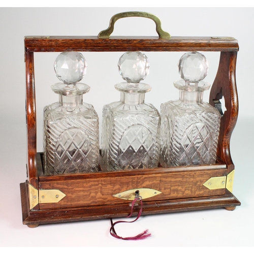 896 - Oak three decanter tantalus, with brass mounts, a few chips, height 32cm, width 36cm, depth 14cm app... 