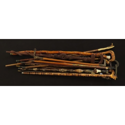 914 - Walking sticks & canes. A collection of fifteen walking sticks & canes, including one with a porcela... 