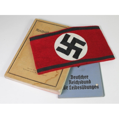 696 - German NSDAP party arm band with German Reichsbund booklet with one other German manual