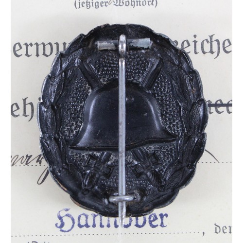 782 - German wound badge in black with 1936 dated award document.