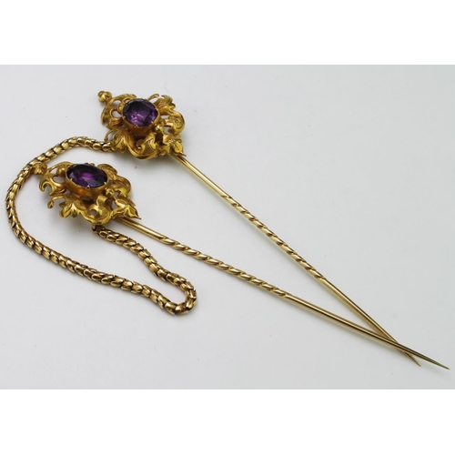 135 - Matching pair of yellow metal (tests as 18ct) stick pins with amethyst stone in centre, joined by a ... 